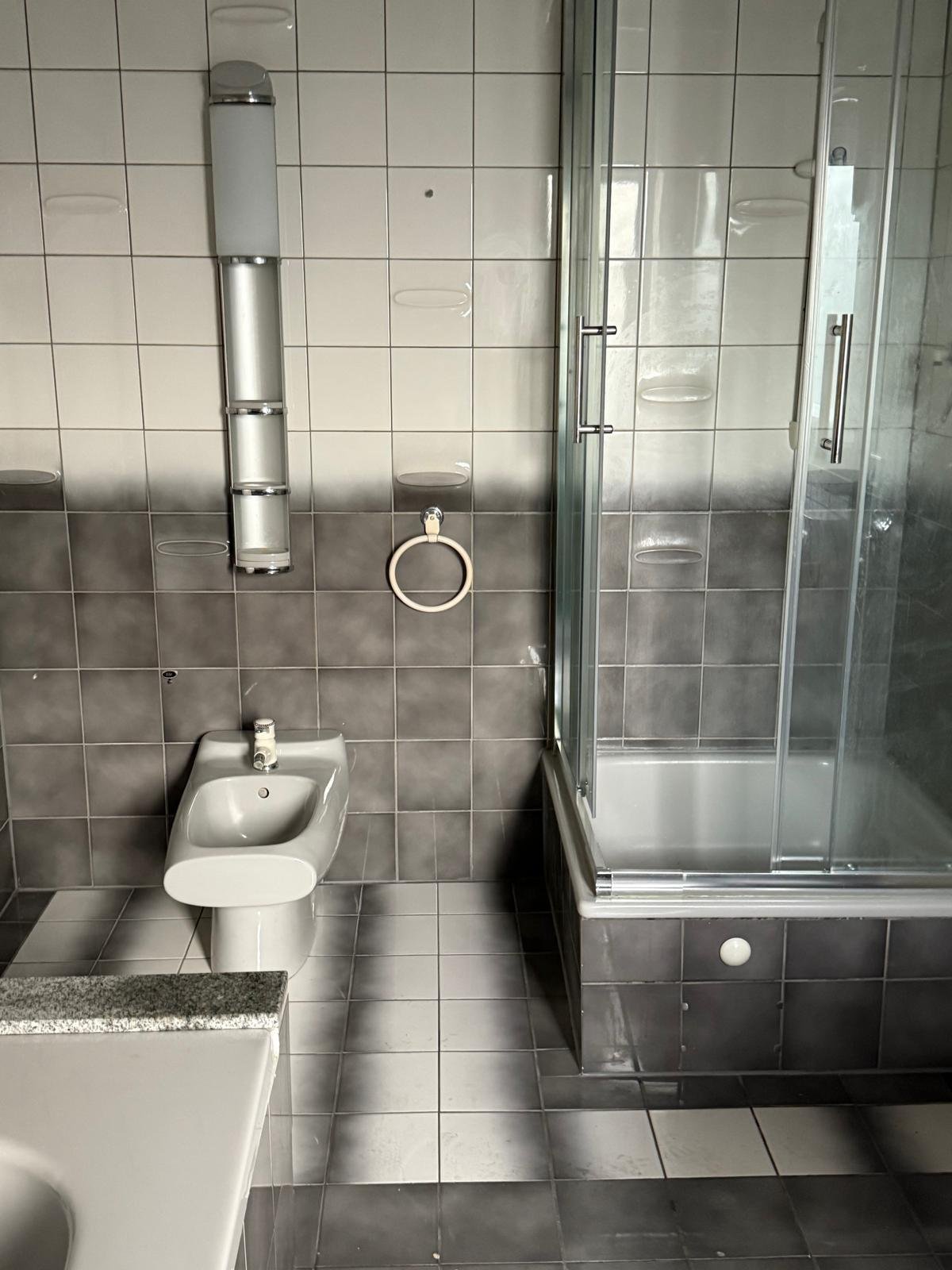 Modernes Badezimmer mit Komfort: Edle Glasdusche und Designer-Sanitärinstallationen in harmonischem Grau-Weiß-Kontrast Modernes Badezimmer mit Komfort: Edle Glasdusche und Designer-Sanitärinstallationen in harmonischem Grau-Weiß-Kontrast