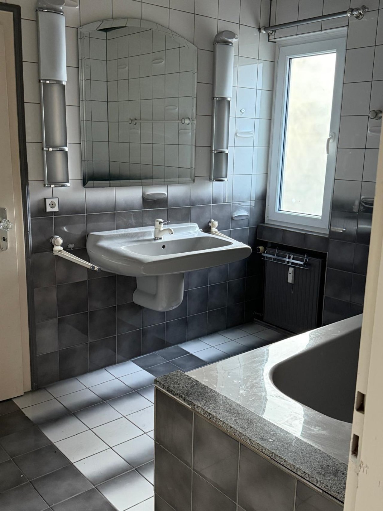 Modernes Tageslicht-Badezimmer mit großzügiger Waschtisch-Lösung und praktischem Granitablageboard