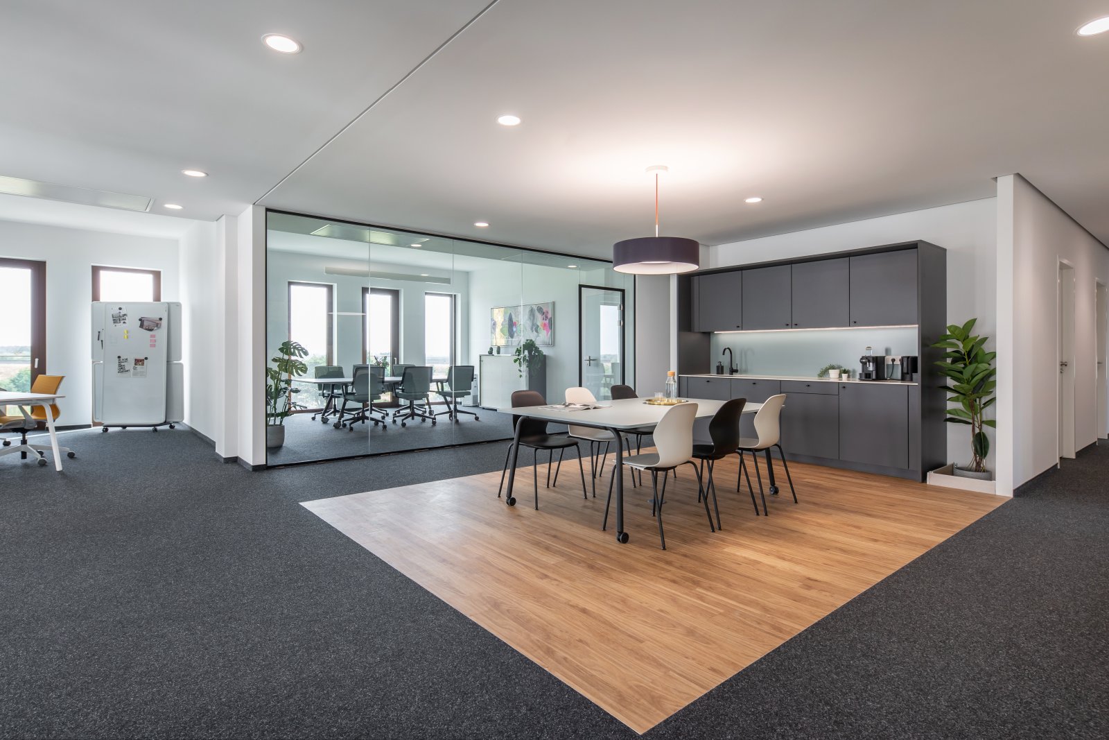 Moderne Bürofläche mit flexiblem Raumkonzept: Glastrennwände, integrierte Küche und ergonomische Arbeitsumgebung Moderne Bürofläche mit flexiblem Raumkonzept: Glastrennwände, integrierte Küche und ergonomische Arbeitsumgebung