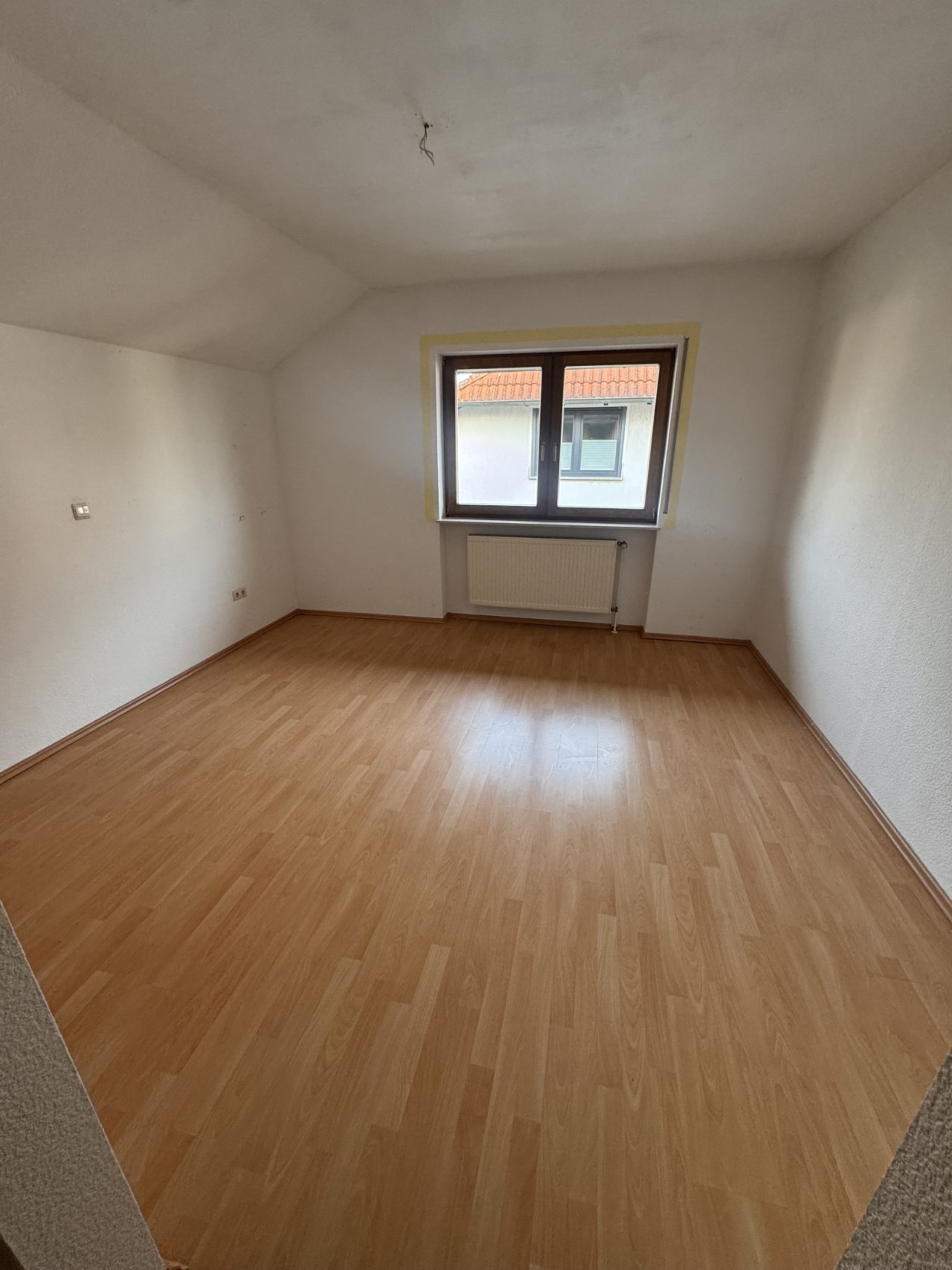 Helles Zimmer mit Fensterfront und Heizanlage