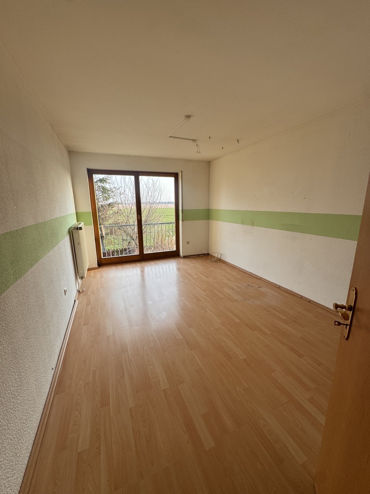 Helles Zimmer mit Balkonzugang und offener Raumgestaltung