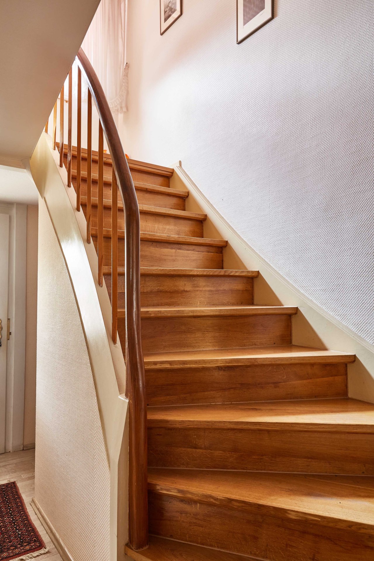 Elegante Holztreppe mit massivem Handlauf – Verbindung zwischen den Wohnebenen
