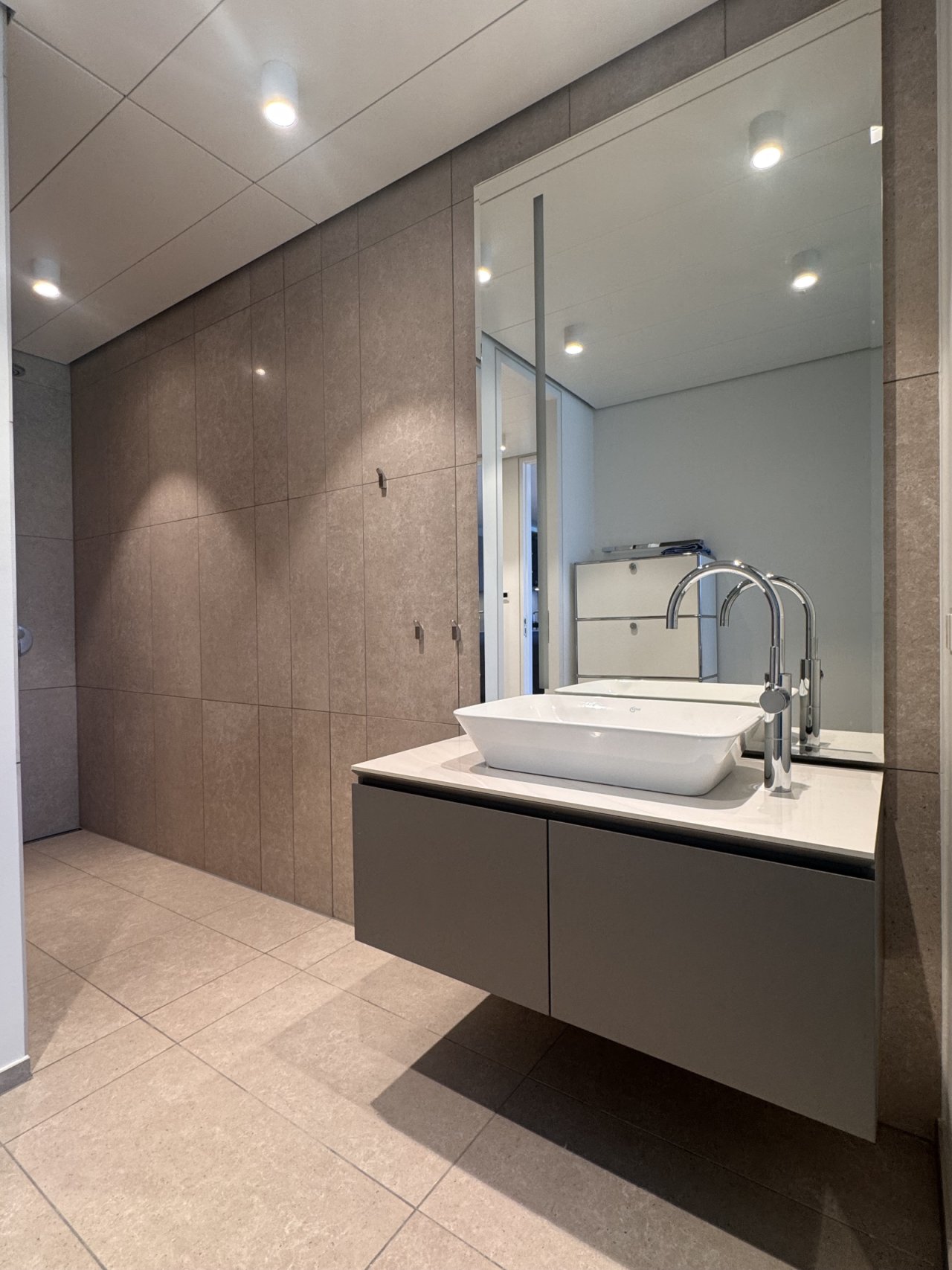 Modernes Badezimmer mit begehbarer Dusche und hochwertiger Ausstattung