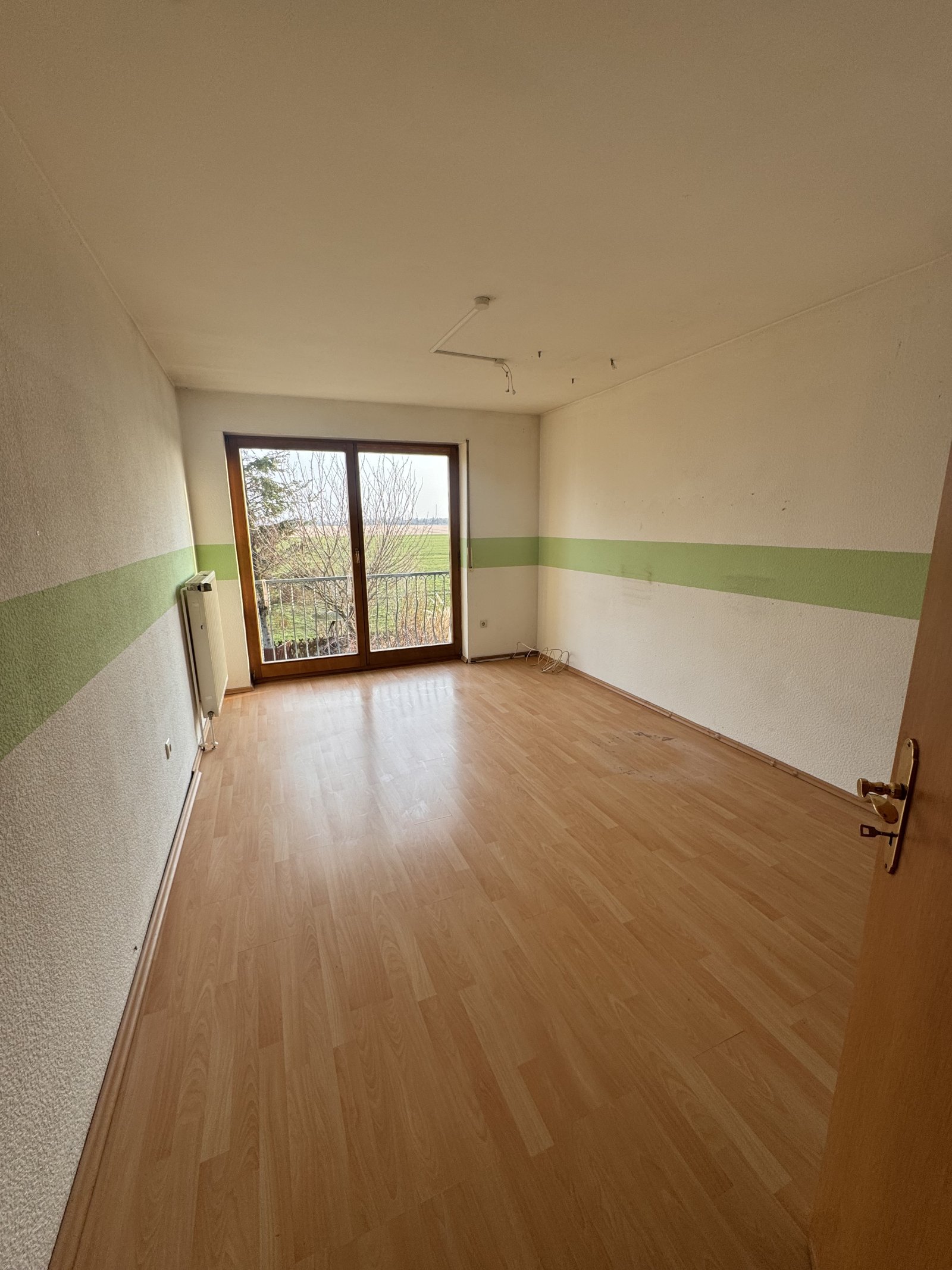 Helles Zimmer mit Balkonzugang und offener Raumgestaltung