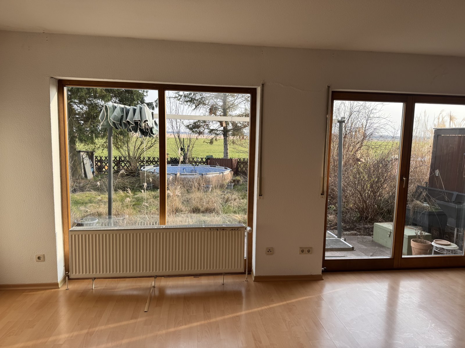 Wohnzimmer mit großflächigen Glasschiebetüren und freiem Blick ins Grüne