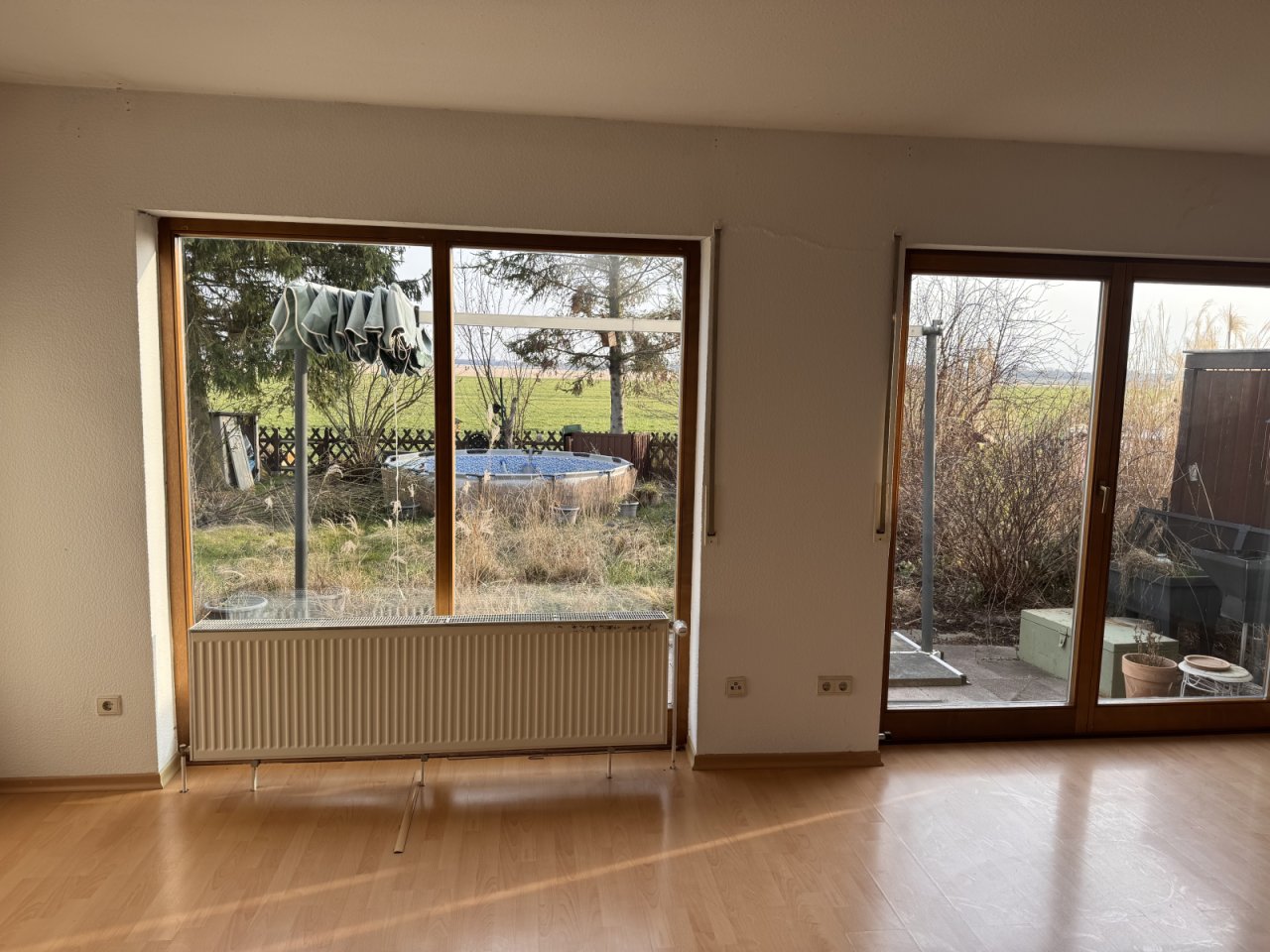 Wohnzimmer mit großflächigen Glasschiebetüren und freiem Blick ins Grüne