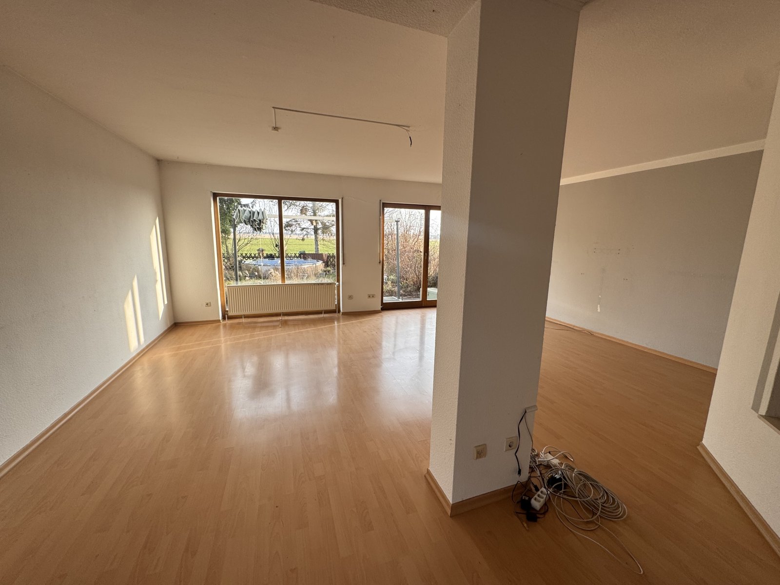 Offenes Wohnzimmer mit raumhohen Glasschiebetüren und flexibler Raumaufteilung