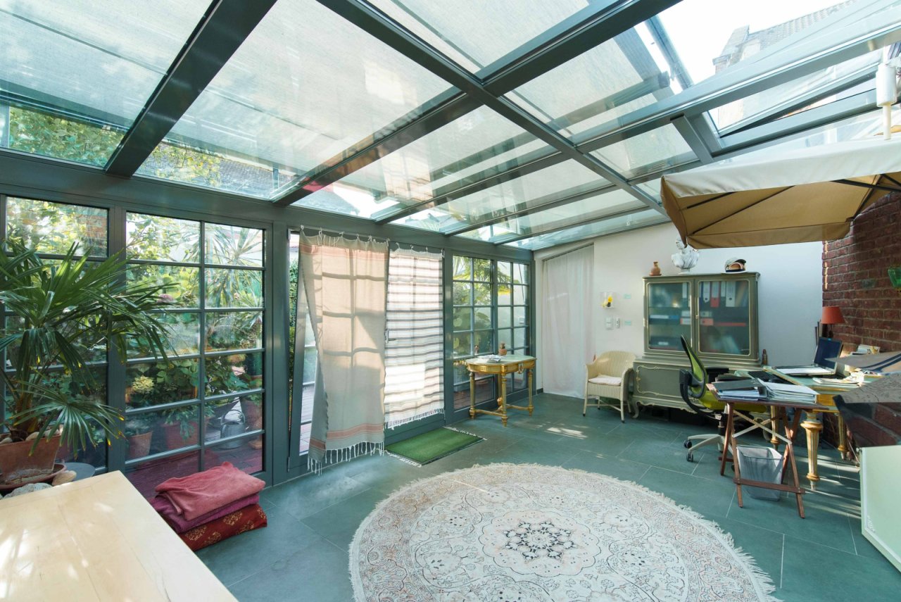 Sunlit winter garden with workspace - your cozy retreat between greenery and glass Sunlit winter garden with workspace - your cozy retreat between greenery and glass