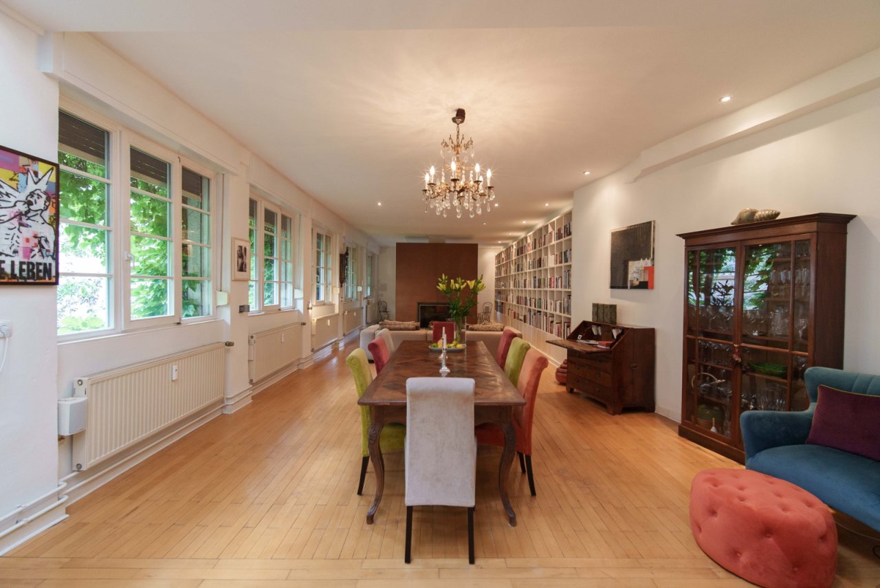 Bright living and dining area with an elegant bookshelf and a dreamy garden view Bright living and dining area with an elegant bookshelf and a dreamy garden view