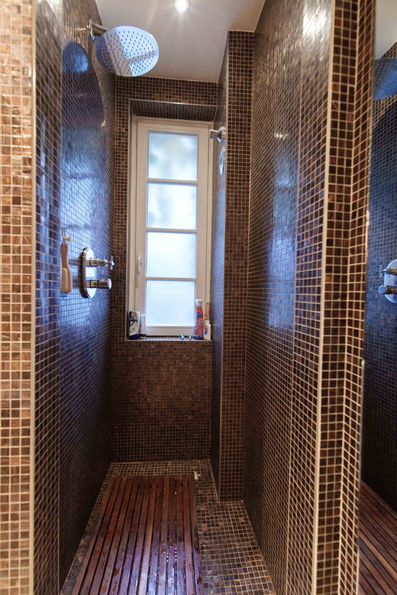 Wellness oasis with natural light: luxurious rainforest shower with natural ventilation and high-quality wooden slats Wellness oasis with natural light: luxurious rainforest shower with natural ventilation and high-quality wooden slats