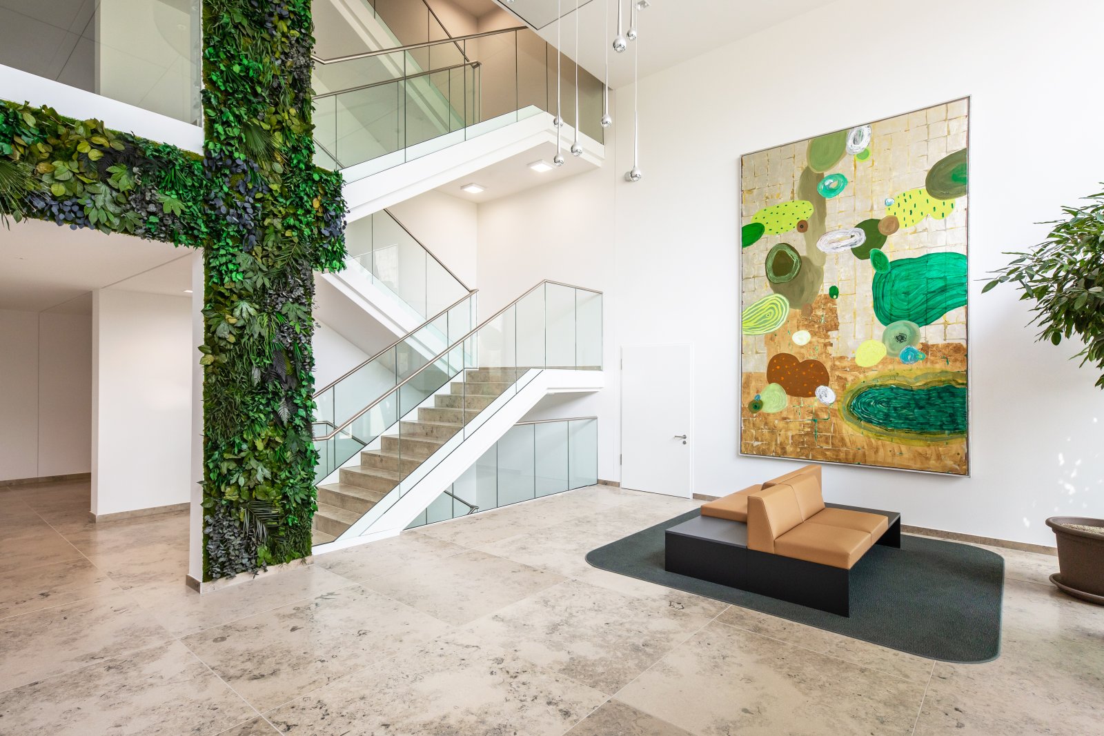 Sustainable design meets modern architecture: light-filled entrance with vertical green wall and elegant glass staircase Sustainable design meets modern architecture: light-filled entrance with vertical green wall and elegant glass staircase