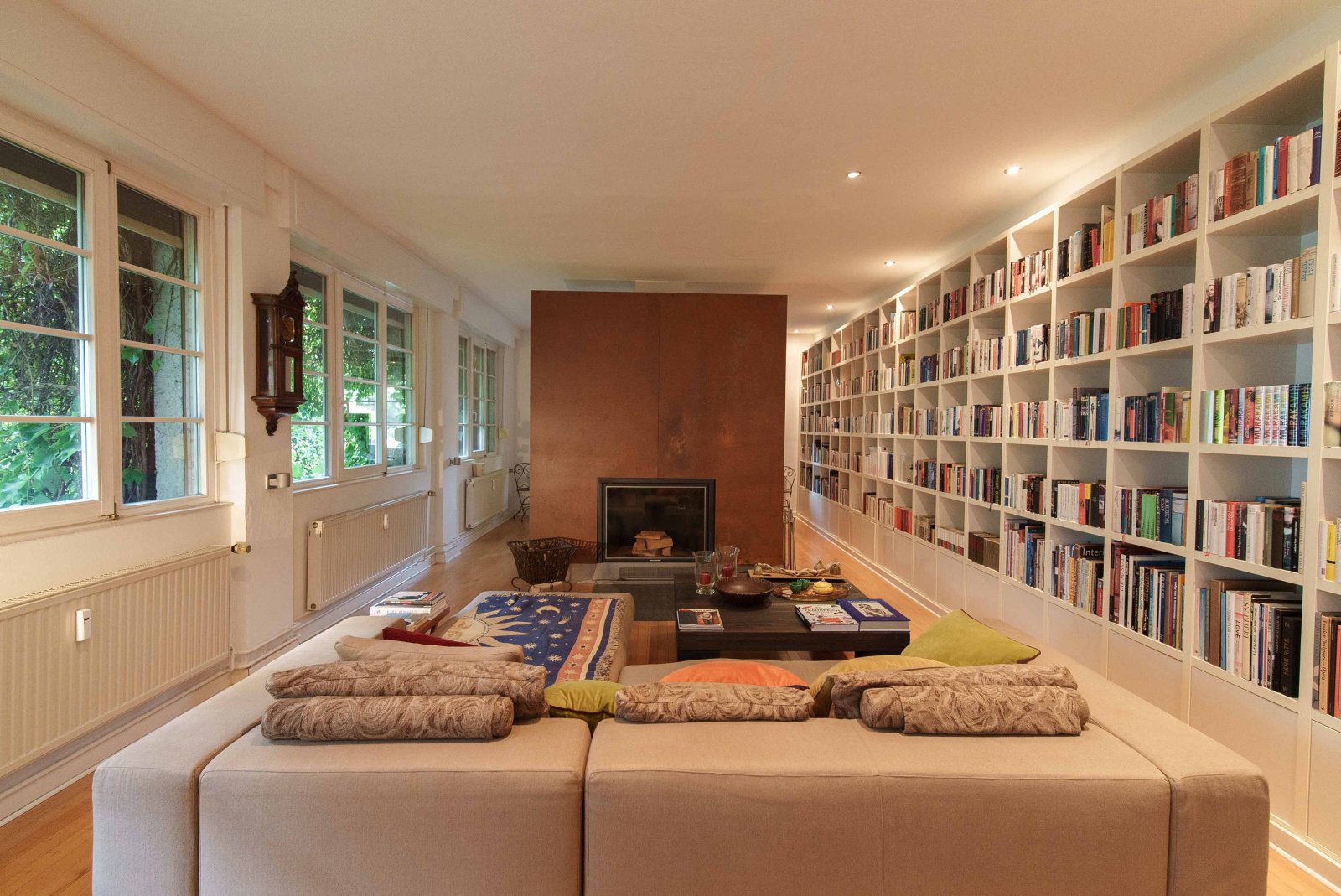 Brightly lit library living space with an elegant fireplace – your retreat for reading and relaxing!