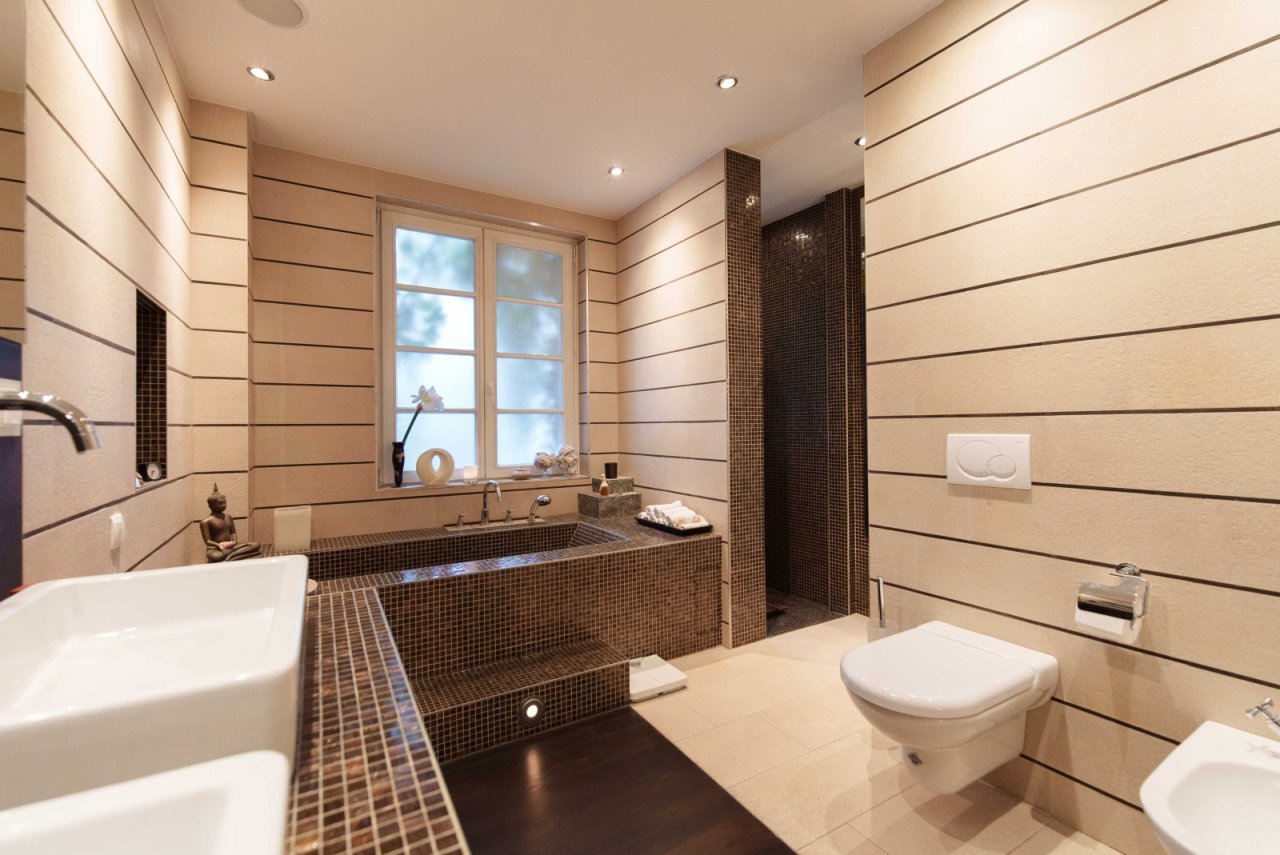 Wellness oasis with natural light: exclusive mosaic bathroom with spacious shower and elegant room design
