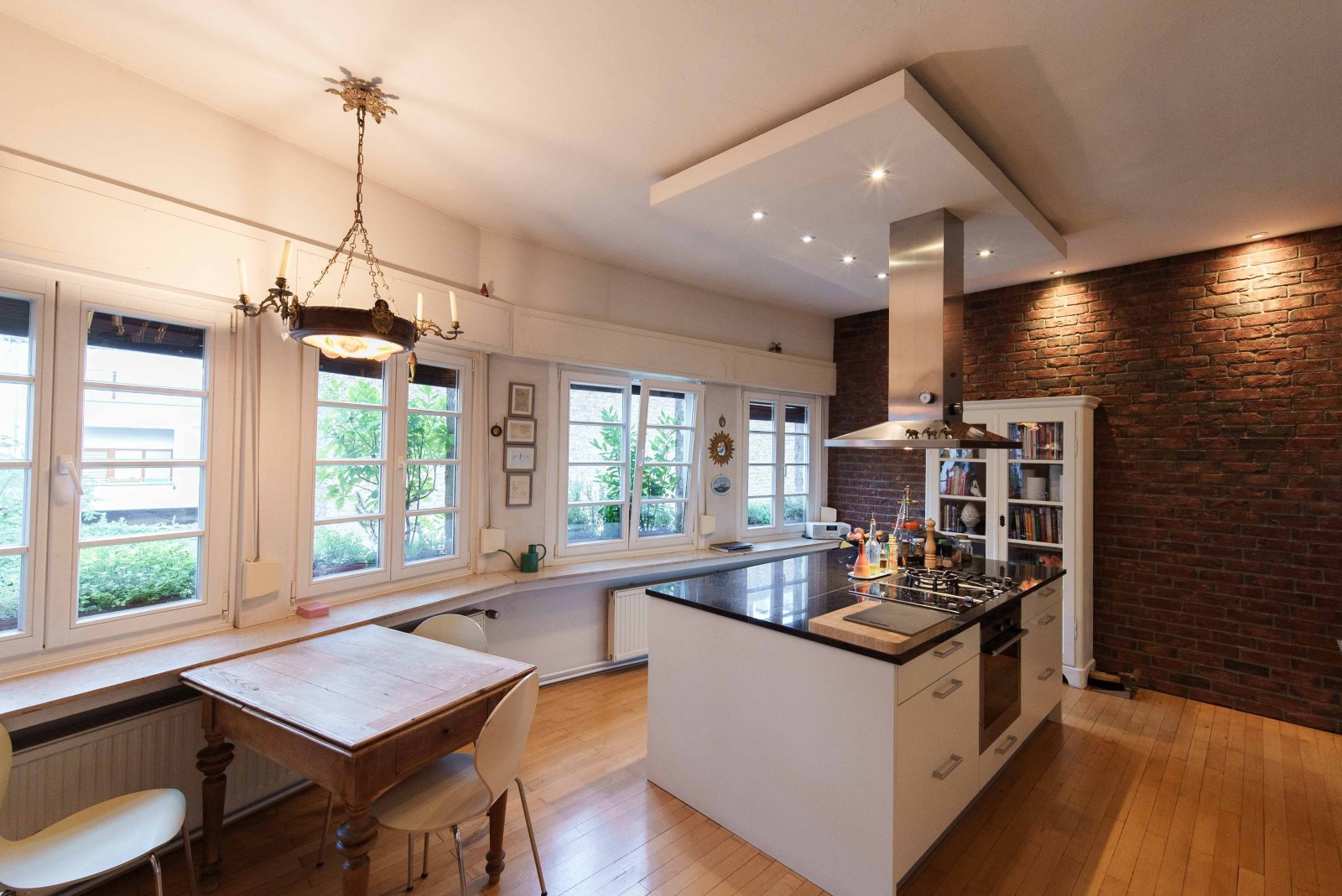 Brightly lit designer kitchen with charm: modern functionality meets rustic brick wall