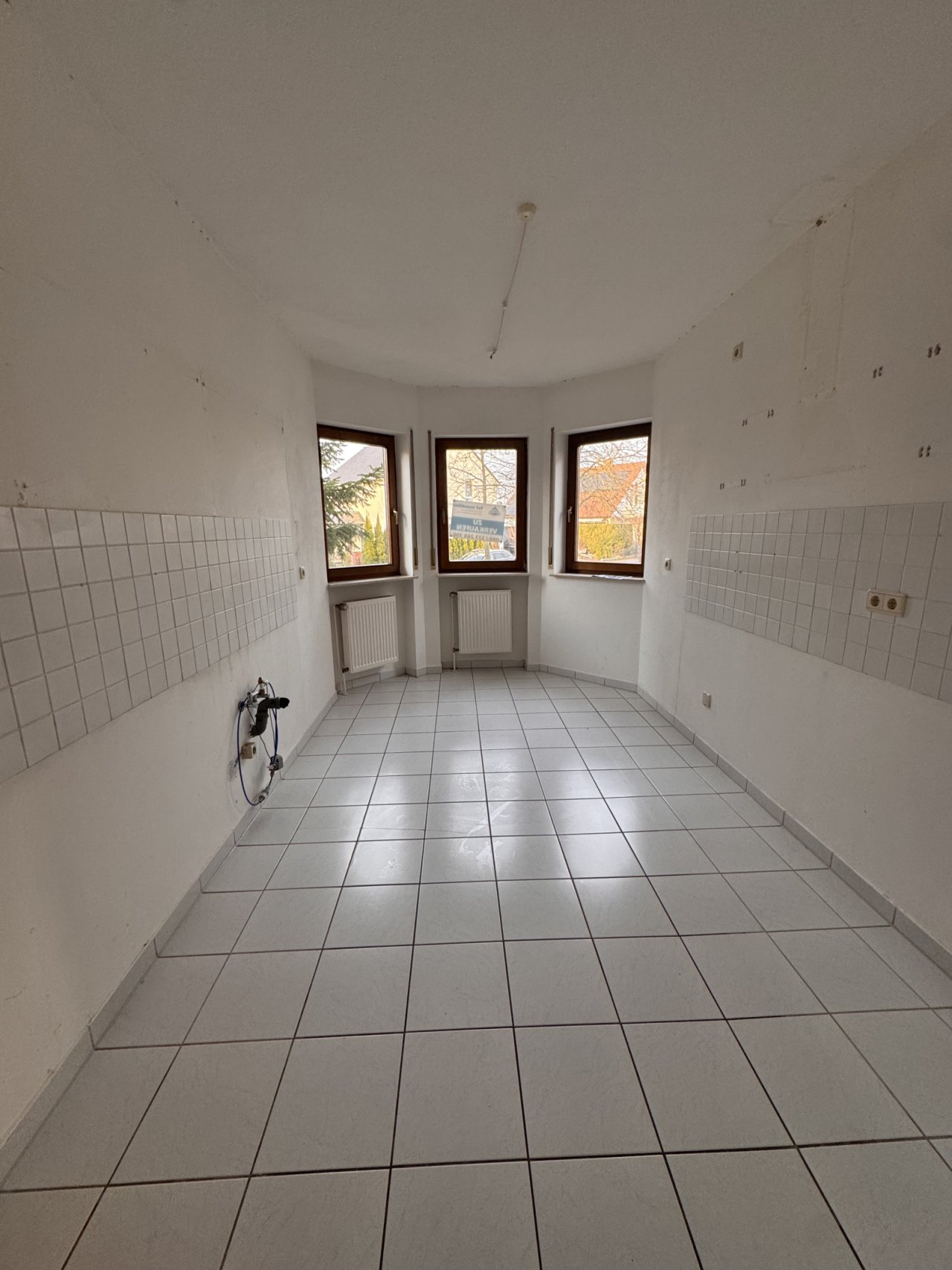 Bright bathroom with large window front and practical furnishings.