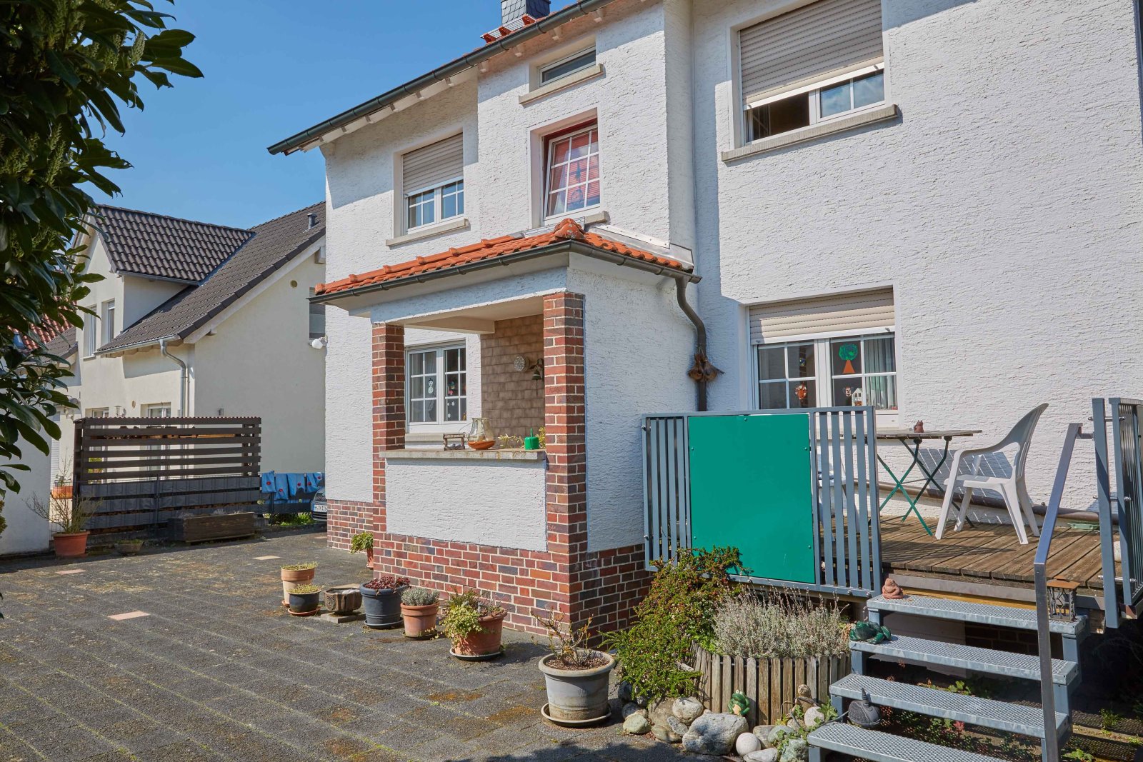 Paved outdoor area with a covered entrance and direct terrace access