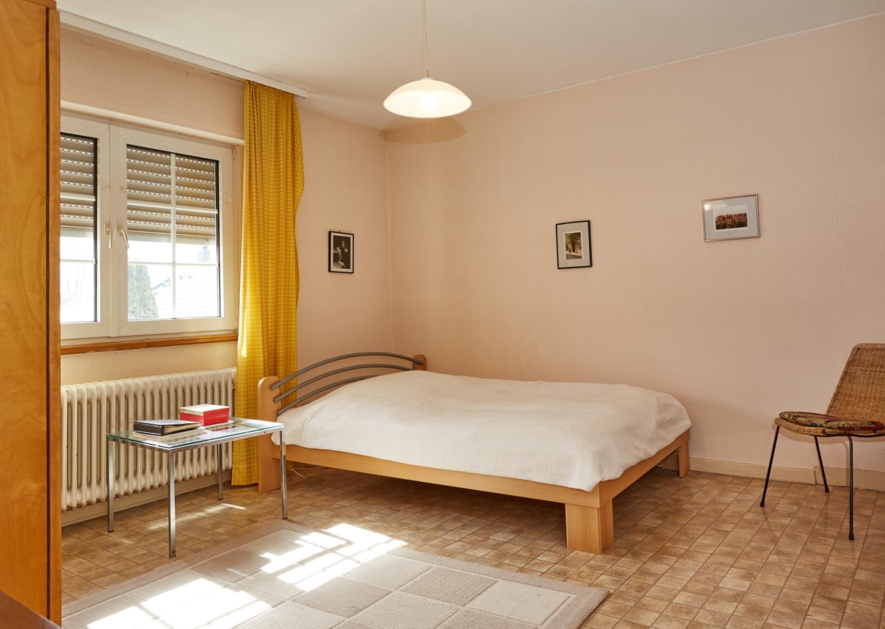 Bright bedroom with window front and traditional heating system