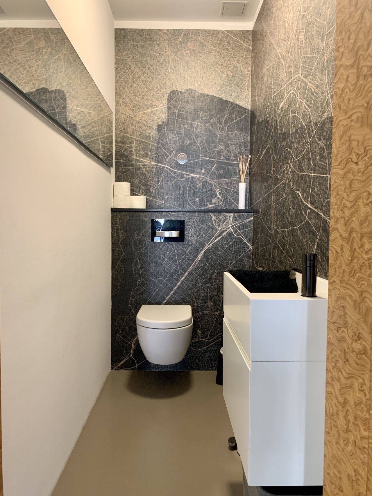 Elegant guest toilet with high-quality ceramic tiling and integrated washbasin Elegant guest toilet with high-quality ceramic tiling and integrated washbasin
