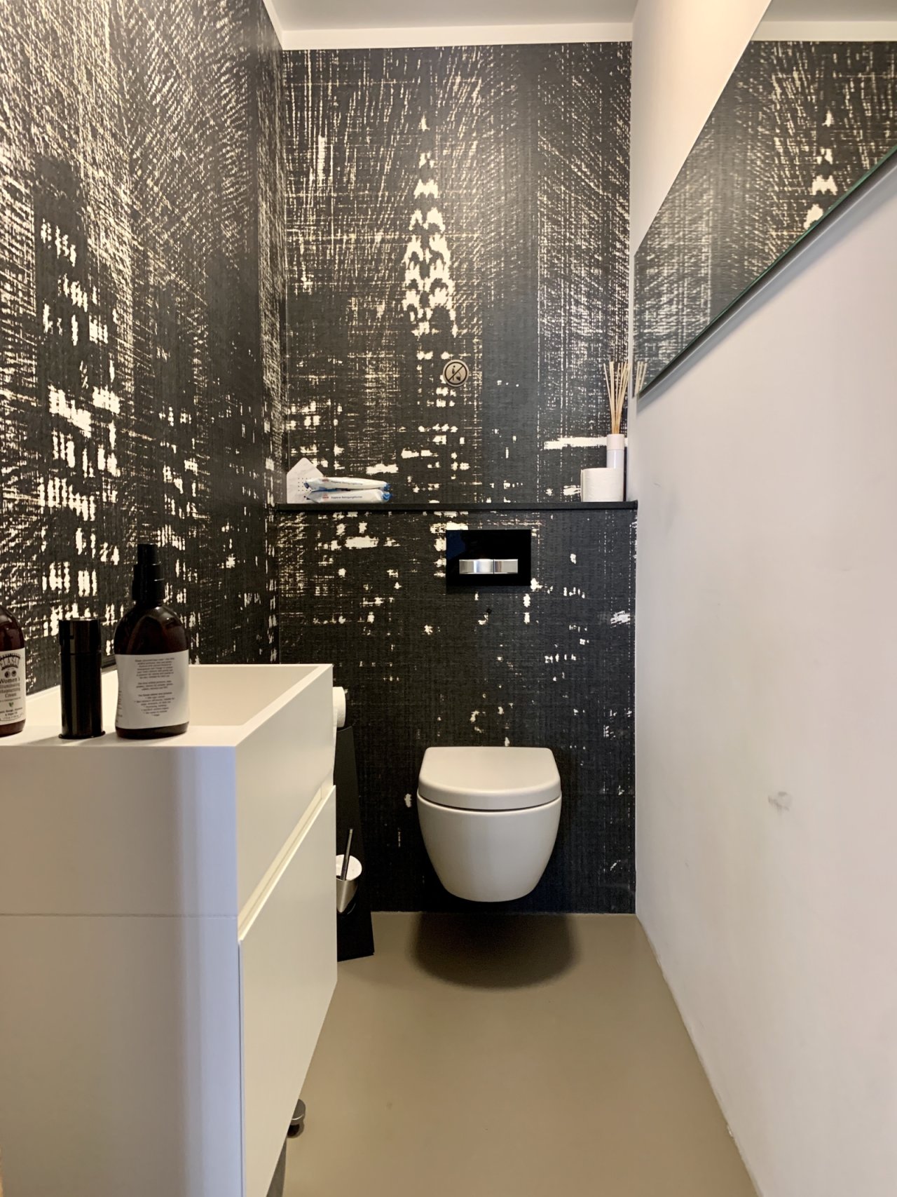 Stylish guest WC with wall-mounted toilet and high-quality mosaic wall cladding Stylish guest WC with wall-mounted toilet and high-quality mosaic wall cladding