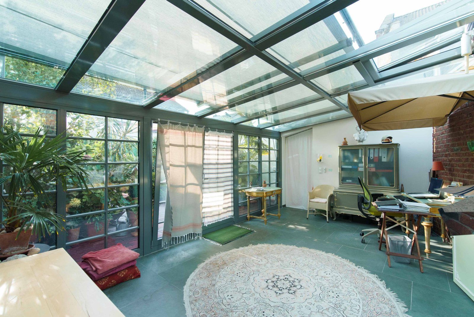 Sunlit winter garden with workspace - your cozy retreat between greenery and glass Sunlit winter garden with workspace - your cozy retreat between greenery and glass