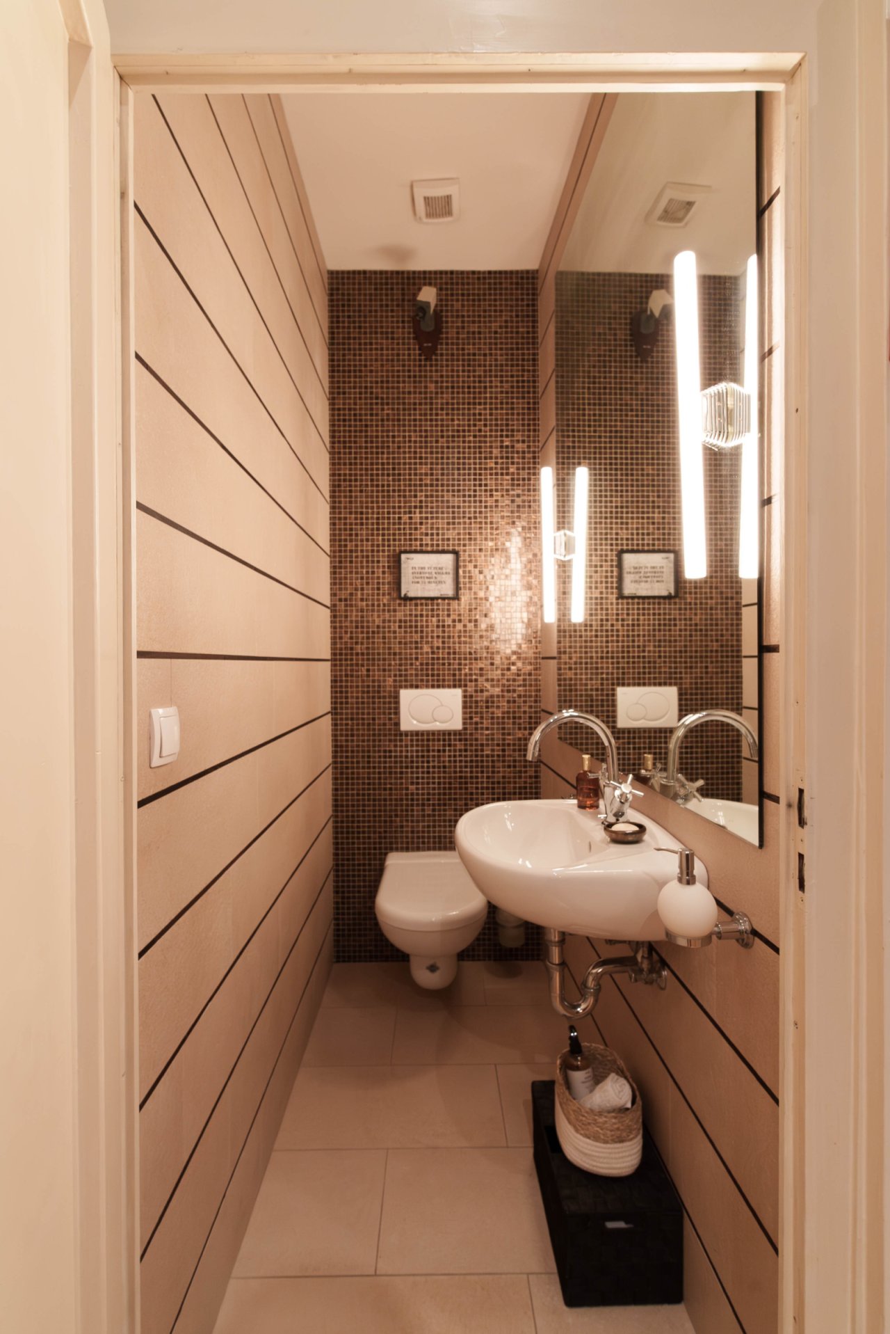 Exclusive guest toilet with designer mosaic wall and clever space utilization Exclusive guest toilet with designer mosaic wall and clever space utilization